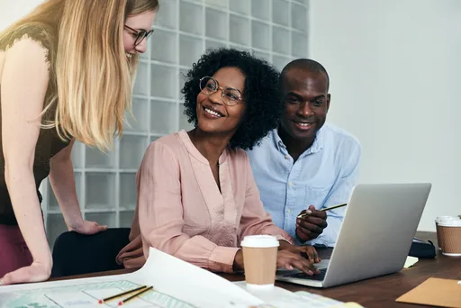 A small team collaborating around a laptop